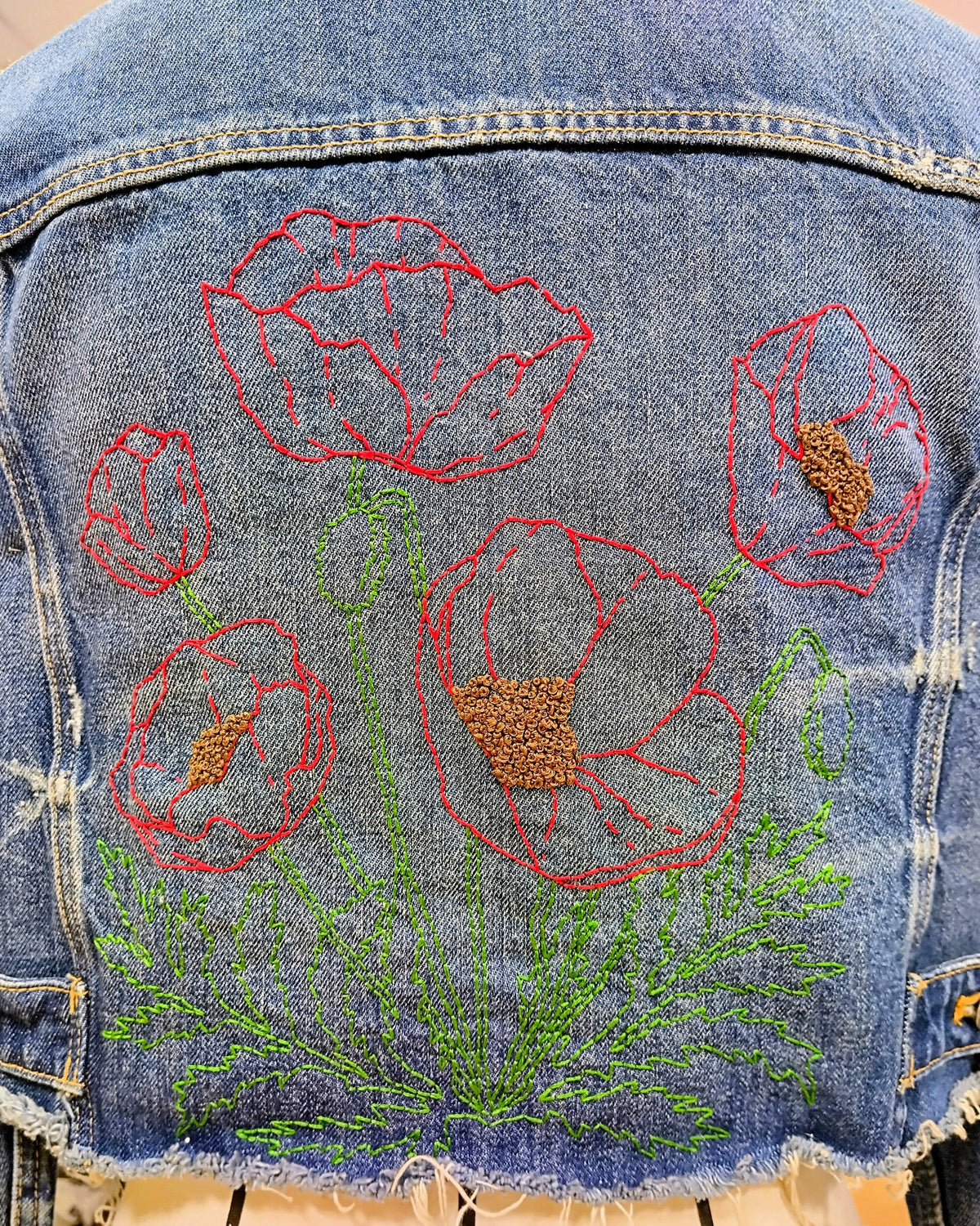 Trasera de chaqueta vaquera personalizada con bordado de amapolas.
