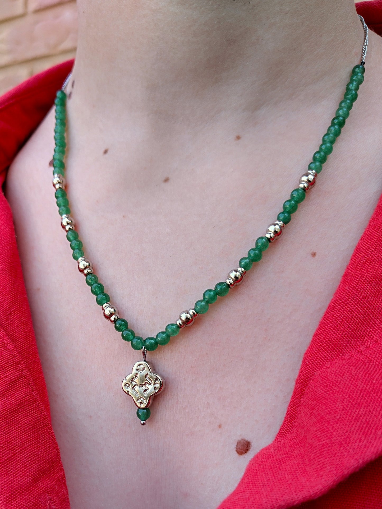 Collar de cuentas de piedra verdes y de metal plateadas. Con cadena y colgante abstracto plata.