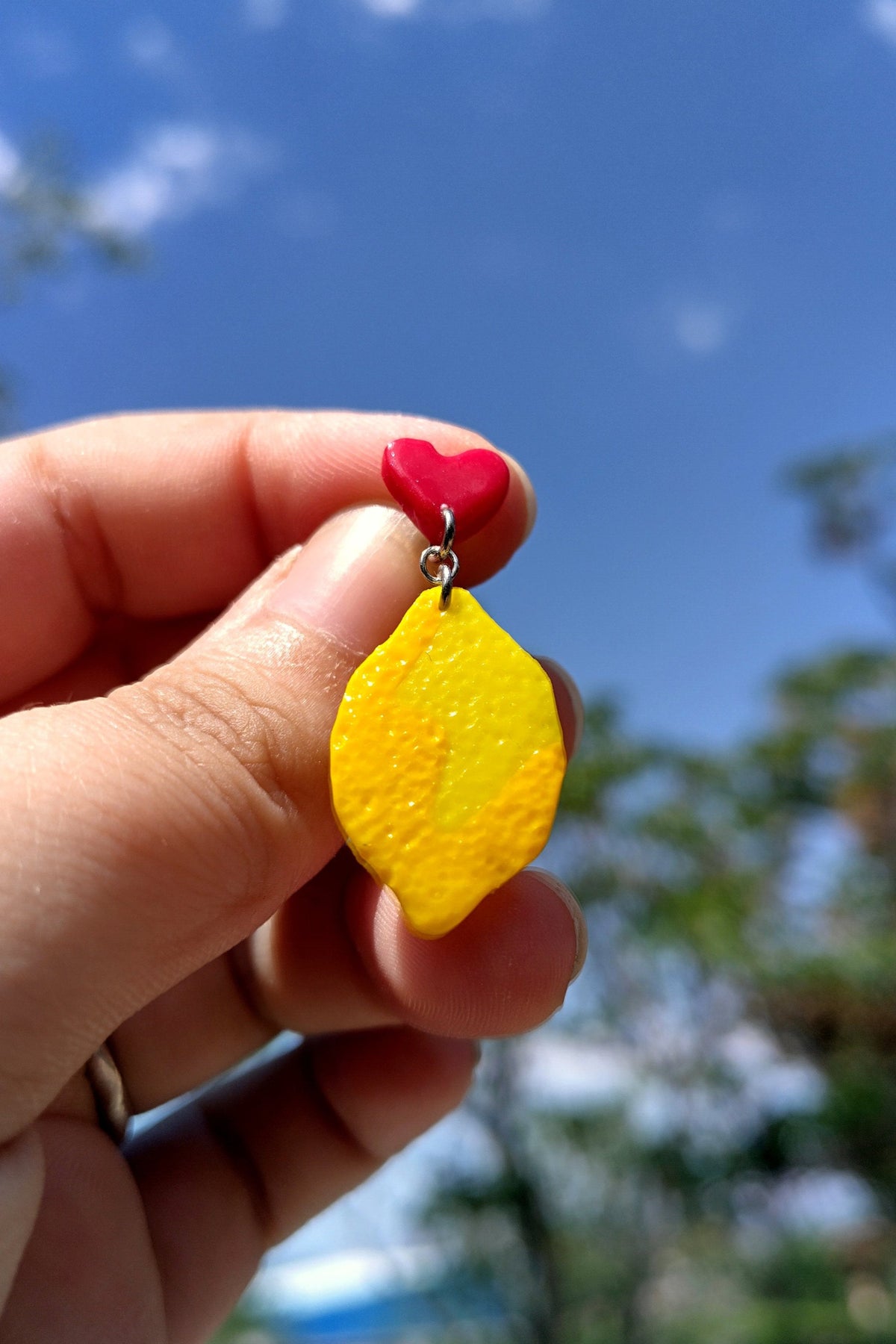 Pendientes de limones colgando de corazones rojos pequeños. Primaverales y con agradable textura.