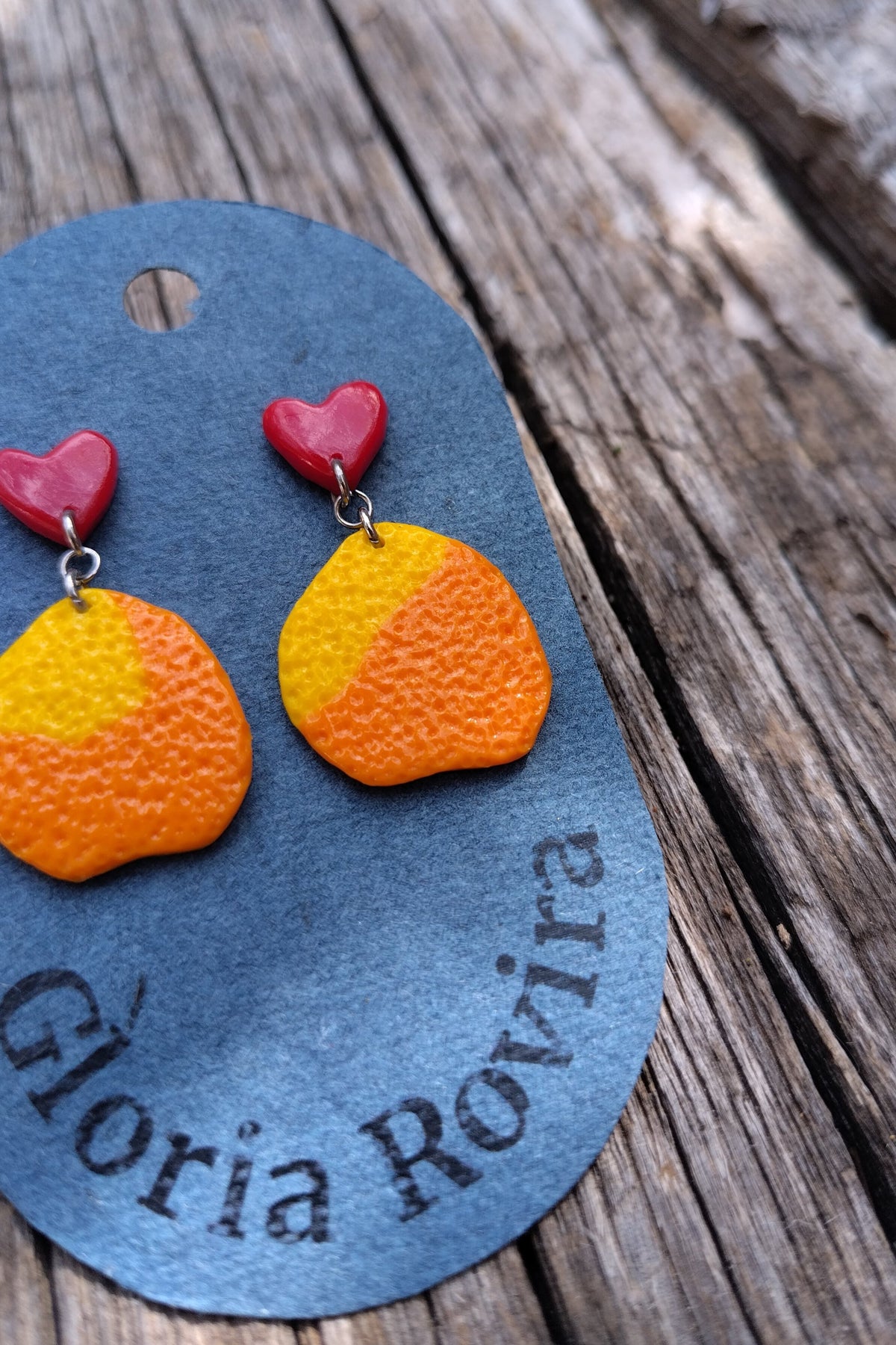 Pendientes de naranjas colgando de corazones rojos pequeños. Primaverales y con agradable textura.