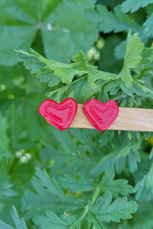 Pendientes de corazones rojos de arcilla polimérica y acero inoxidable, dulces y discretos; pegados al lóbulo.